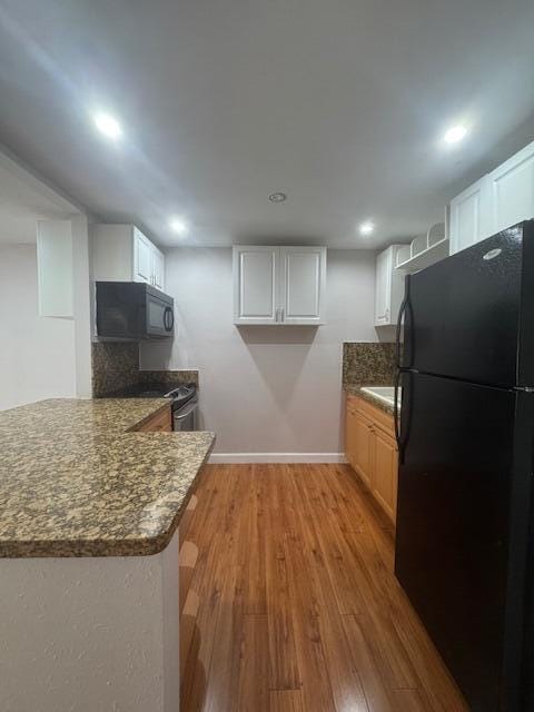 6080 Forest Hill Blvd Unit 201, West Palm Beach, FL 33415 - kitchen featuring black appliances, light wood-style flooring, a peninsula, white cabinetry, and recessed lighting