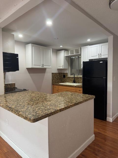 6080 Forest Hill Blvd Unit 201, West Palm Beach, FL 33415 - kitchen featuring black appliances, a sink, dark wood finished floors, a peninsula, and white cabinetry