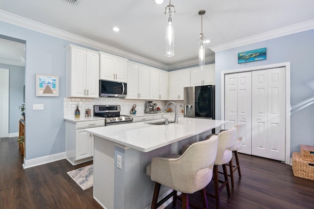 260 SE Via Visconti, Port Saint Lucie, FL 34952 - kitchen with appliances with stainless steel finishes, a sink, ornamental molding, white cabinetry, and dark wood finished floors