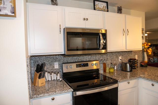1122 SW California Blvd SW, Port Saint Lucie, FL 34953 - kitchen with appliances with stainless steel finishes, backsplash, white cabinets, and light stone countertops