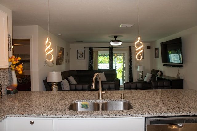 1122 SW California Blvd SW, Port Saint Lucie, FL 34953 - kitchen featuring stainless steel dishwasher, a sink, open floor plan, white cabinetry, and light stone countertops