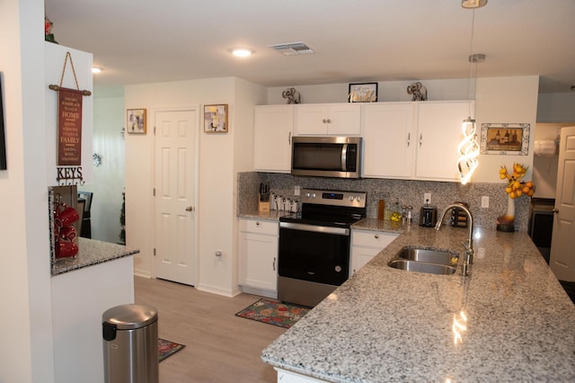 1122 SW California Blvd SW, Port Saint Lucie, FL 34953 - kitchen featuring appliances with stainless steel finishes, a sink, white cabinetry, and backsplash
