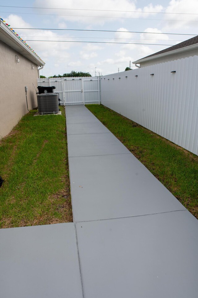 1122 SW California Blvd SW, Port Saint Lucie, FL 34953 - view of yard featuring central AC unit and a gate