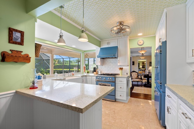 4633 Holly Dr, Palm Beach Gardens, FL 33418 - kitchen with high end stainless steel range oven, ventilation hood, ornamental molding, freestanding refrigerator, and white cabinetry