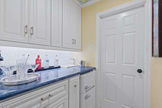 4633 Holly Dr, Palm Beach Gardens, FL 33418 - kitchen featuring tasteful backsplash, white cabinetry, refrigerator, and dark stone countertops