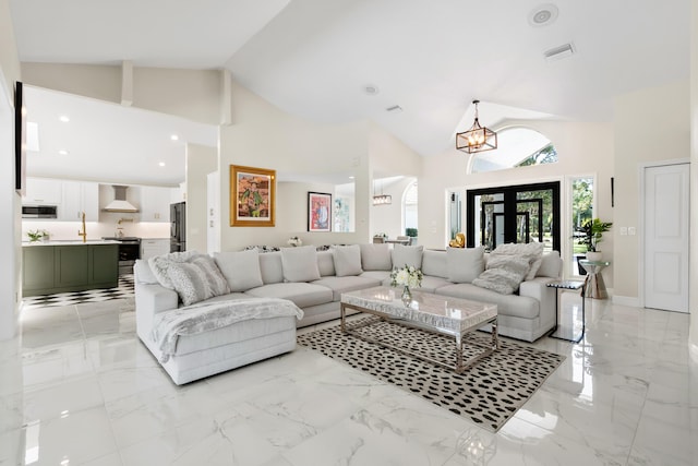 4902 SW Bimini Cir N, Palm City, FL 34990 - living area featuring a chandelier, light marble finish flooring, and high vaulted ceiling