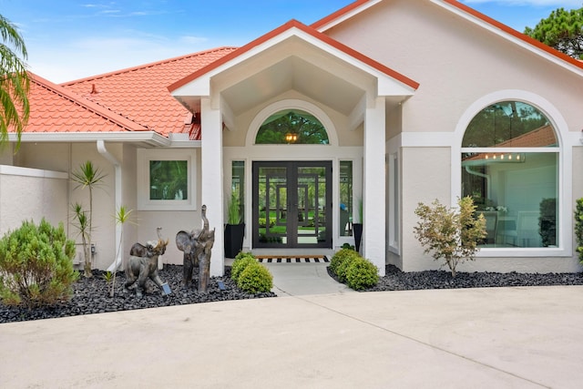 4902 SW Bimini Cir N, Palm City, FL 34990 - property entrance with french doors, stucco siding, and a tile roof