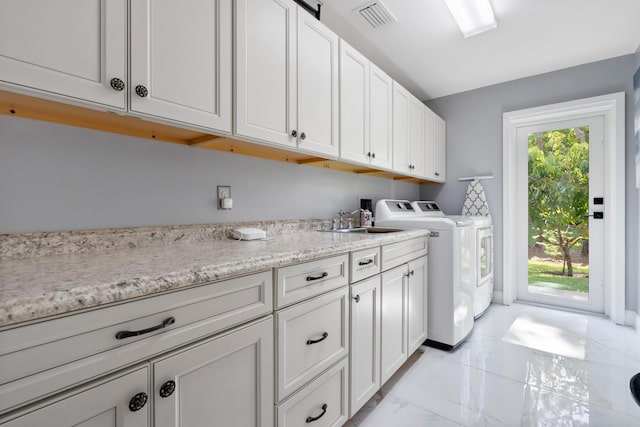 4902 SW Bimini Cir N, Palm City, FL 34990 - laundry area with light marble finish flooring, cabinet space, and washing machine and dryer