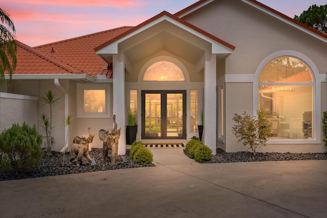 4902 SW Bimini Cir N, Palm City, FL 34990 - view of exterior entry featuring stucco siding, french doors, and a tiled roof