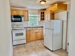 1260 Dr Martin Luther King Jr Blvd, Riviera Beach, FL 33404 - kitchen featuring white appliances, a sink, light brown cabinetry, and light countertops
