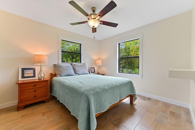 17183 76th St N, Loxahatchee, FL 33470 - bedroom featuring multiple windows, baseboards, and light wood-type flooring