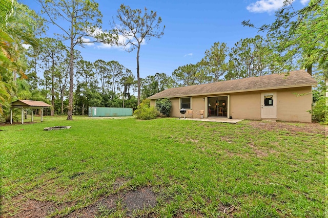 17183 76th St N, Loxahatchee, FL 33470 - view of green lawn featuring an outdoor fire pit and a patio