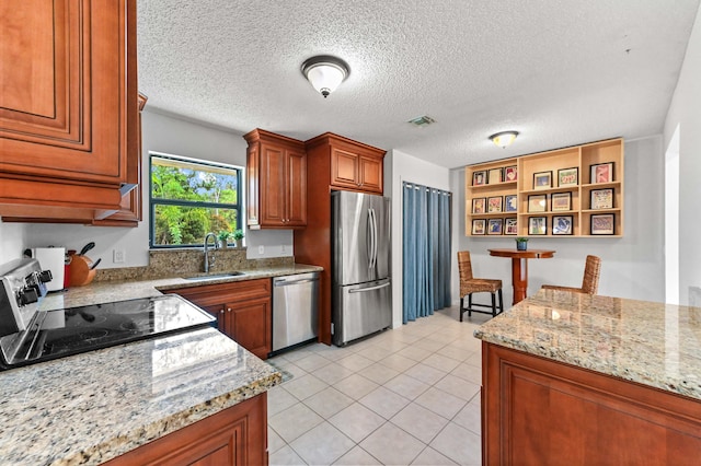 17183 76th St N, Loxahatchee, FL 33470 - kitchen with stainless steel appliances, a sink, brown cabinets, open shelves, and a textured ceiling
