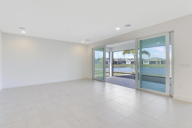 13439 SW River Rock Rd, Port Saint Lucie, FL 34987 - spare room with a water view, recessed lighting, baseboards, and light tile patterned flooring