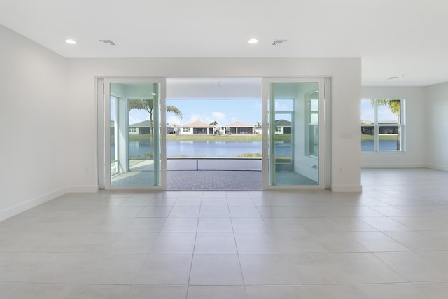 13439 SW River Rock Rd, Port Saint Lucie, FL 34987 - tiled spare room with baseboards, a water view, and recessed lighting