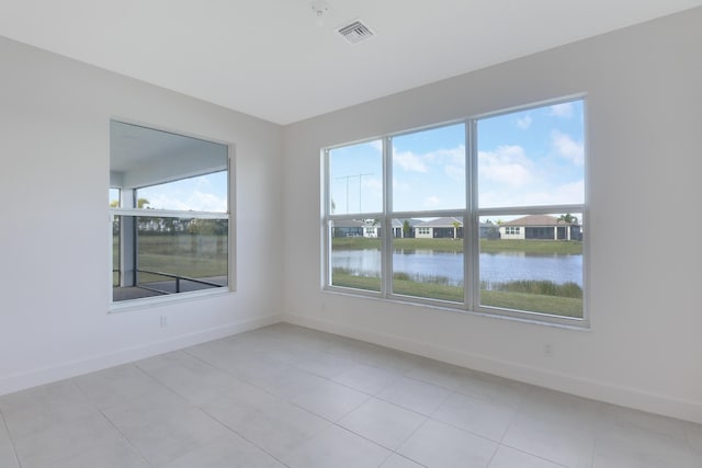 13439 SW River Rock Rd, Port Saint Lucie, FL 34987 - unfurnished room featuring baseboards, a water view, and light tile patterned floors