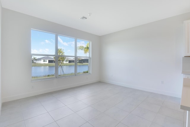 13439 SW River Rock Rd, Port Saint Lucie, FL 34987 - spare room with light tile patterned floors, baseboards, and a water view