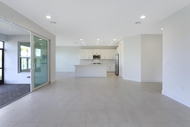 13439 SW River Rock Rd, Port Saint Lucie, FL 34987 - unfurnished living room with a sink, recessed lighting, and baseboards