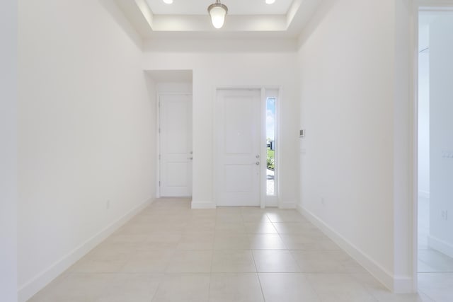 13439 SW River Rock Rd, Port Saint Lucie, FL 34987 - entrance foyer with light tile patterned floors, a tray ceiling, and baseboards