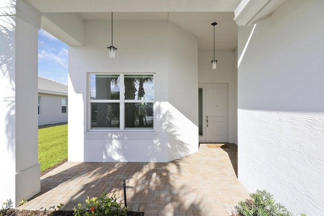 13439 SW River Rock Rd, Port Saint Lucie, FL 34987 - doorway to property with stucco siding and a patio area
