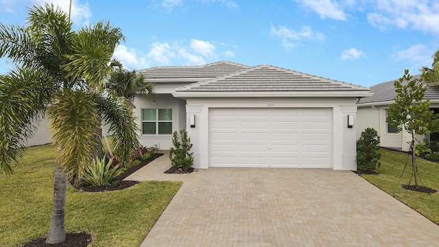 13439 SW River Rock Rd, Port Saint Lucie, FL 34987 - view of front facade featuring stucco siding, decorative driveway, a garage, a front lawn, and a tiled roof