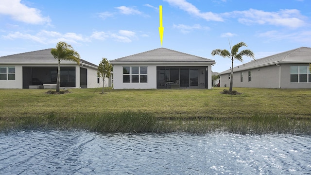 13439 SW River Rock Rd, Port Saint Lucie, FL 34987 - back of house featuring a sunroom, a tile roof, a lawn, and a water view