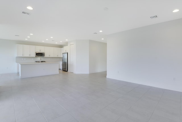 13439 SW River Rock Rd, Port Saint Lucie, FL 34987 - unfurnished living room with recessed lighting and light tile patterned floors