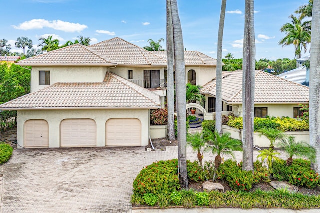 7339 Mandarin Dr, Boca Raton, FL 33433 - view of front of house with driveway, a tile roof, stucco siding, a garage, and a balcony