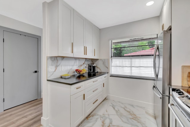 21695 Tall Palm Cir Unit 4B, Boca Raton, FL 33433 - kitchen featuring freestanding refrigerator, gas range, white cabinets, dark countertops, and decorative backsplash
