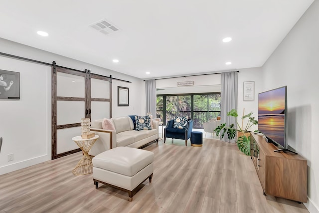 21695 Tall Palm Cir Unit 4B, Boca Raton, FL 33433 - living room featuring a barn door, light wood finished floors, recessed lighting, and baseboards
