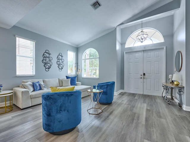 8194 Via Bolzano, Lake Worth, FL 33467 - living room featuring vaulted ceiling, wood finished floors, crown molding, healthy amount of natural light, and a chandelier