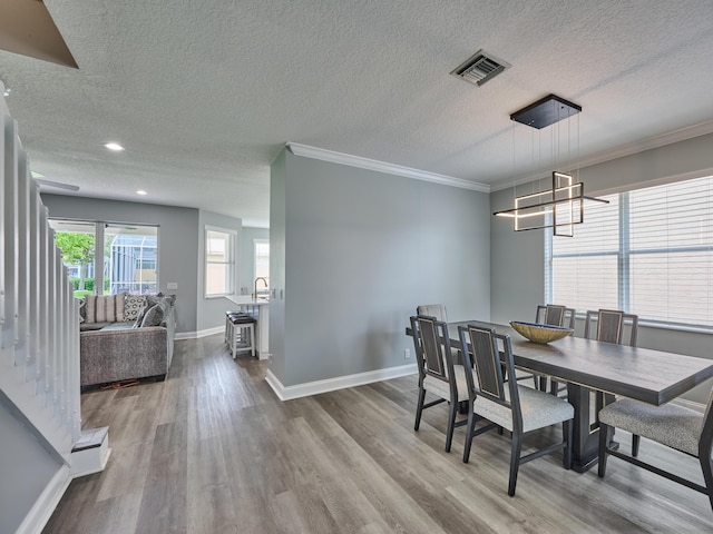 8194 Via Bolzano, Lake Worth, FL 33467 - dining space featuring a chandelier, a textured ceiling, wood finished floors, baseboards, and ornamental molding