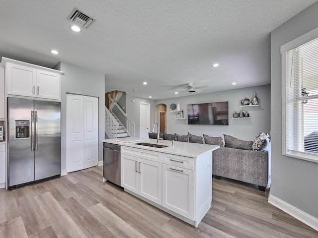 8194 Via Bolzano, Lake Worth, FL 33467 - kitchen featuring stainless steel appliances, a sink, arched walkways, open floor plan, and white cabinetry