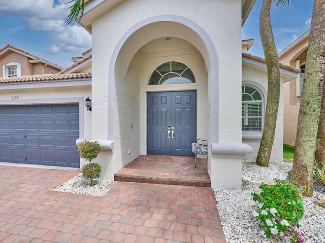 8194 Via Bolzano, Lake Worth, FL 33467 - property entrance featuring stucco siding, a garage, and decorative driveway