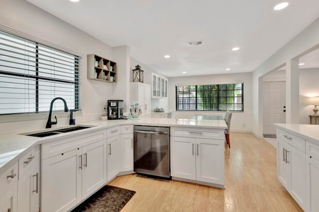 146 Weybridge Cir Unit B, Royal Palm Beach, FL 33411 - kitchen featuring stainless steel dishwasher, a sink, a peninsula, white cabinets, and light wood-type flooring