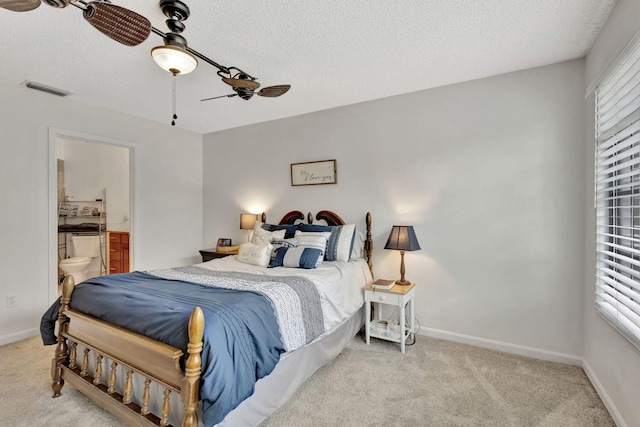 146 Weybridge Cir Unit B, Royal Palm Beach, FL 33411 - bedroom featuring a textured ceiling, light colored carpet, ensuite bathroom, baseboards, and ceiling fan