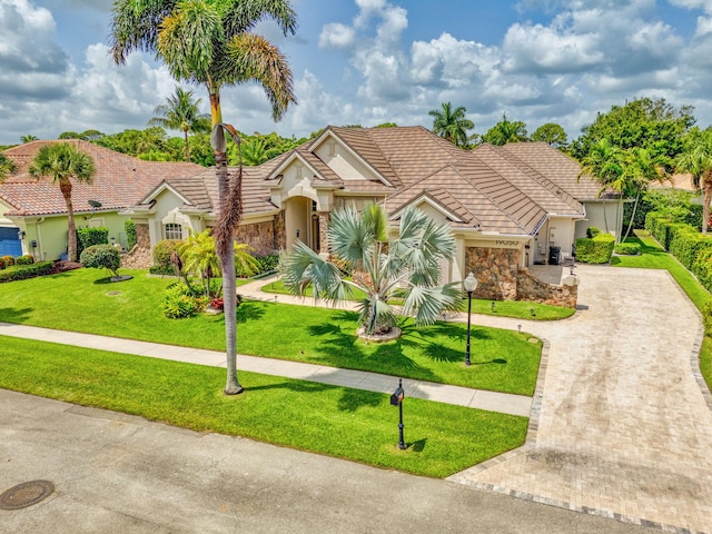 19050 SE Kokomo Ln, Jupiter, FL 33458 - single story home with curved driveway, a tile roof, stucco siding, and a front lawn