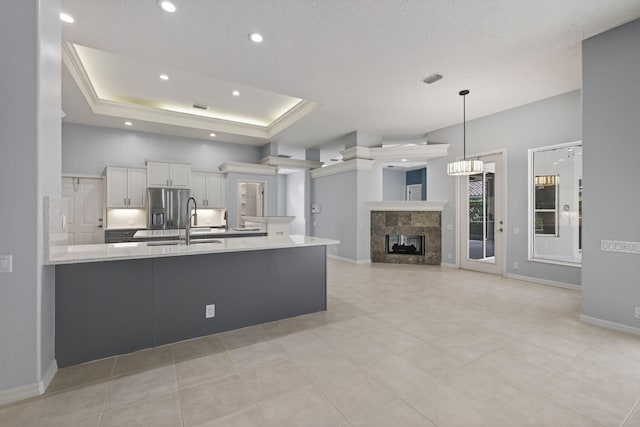 19050 SE Kokomo Ln, Jupiter, FL 33458 - kitchen with a peninsula, white cabinetry, a high end fireplace, stainless steel refrigerator with ice dispenser, and recessed lighting