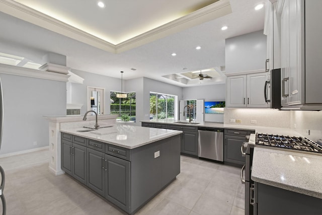 19050 SE Kokomo Ln, Jupiter, FL 33458 - kitchen featuring appliances with stainless steel finishes, a raised ceiling, gray cabinetry, a kitchen island with sink, and a ceiling fan