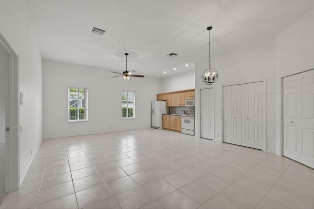 19050 SE Kokomo Ln, Jupiter, FL 33458 - unfurnished living room with ceiling fan, a chandelier, light tile patterned floors, and recessed lighting