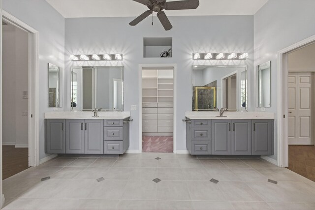19050 SE Kokomo Ln, Jupiter, FL 33458 - bathroom featuring ceiling fan, tile patterned floors, two vanities, and a walk in closet