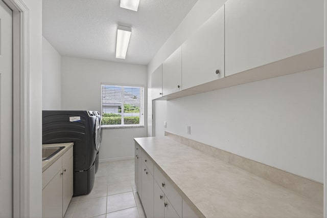 19050 SE Kokomo Ln, Jupiter, FL 33458 - washroom featuring washing machine and clothes dryer, light tile patterned flooring, cabinet space, and a textured ceiling