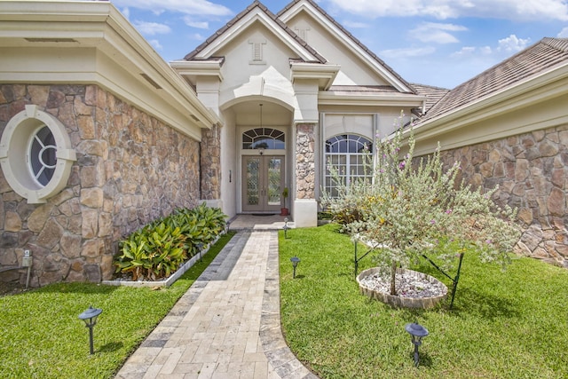 19050 SE Kokomo Ln, Jupiter, FL 33458 - property entrance with french doors, stone siding, and a yard