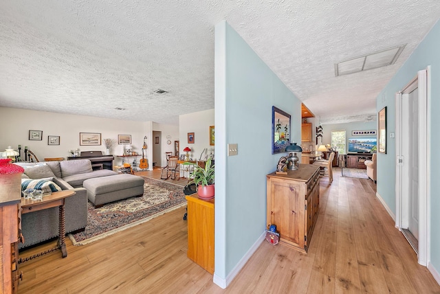 9494 SE Cove Point St, Jupiter, FL 33469 - living area with light wood-style floors, a textured ceiling, and attic access