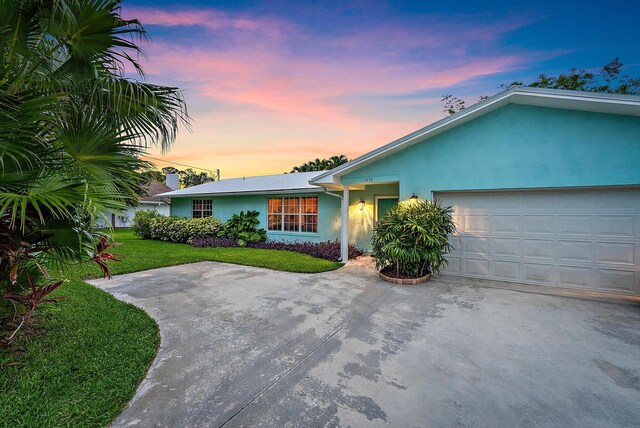 9494 SE Cove Point St, Jupiter, FL 33469 - single story home with stucco siding, a front yard, an attached garage, and driveway