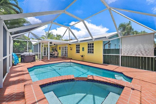 9494 SE Cove Point St, Jupiter, FL 33469 - view of swimming pool with a grill, a pool with connected hot tub, a patio area, french doors, and glass enclosure