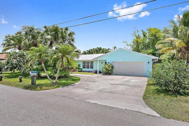 9494 SE Cove Point St, Jupiter, FL 33469 - ranch-style house featuring driveway, a garage, stucco siding, and a front lawn