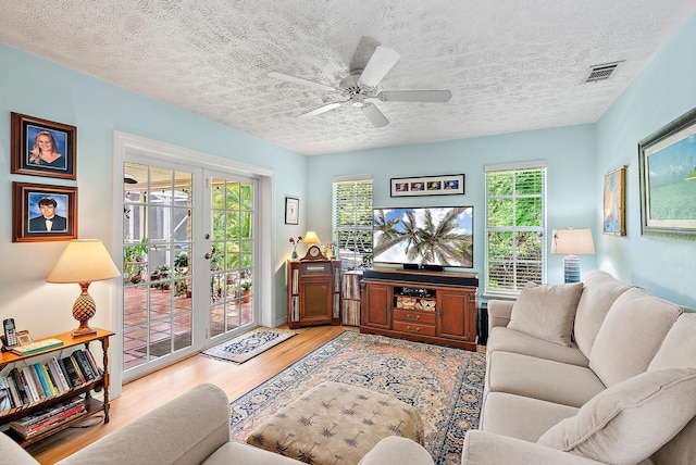 9494 SE Cove Point St, Jupiter, FL 33469 - living room with light wood-style flooring, healthy amount of natural light, a textured ceiling, and a ceiling fan