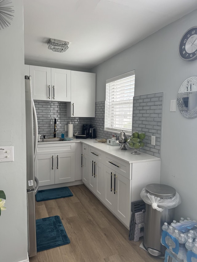 203 S Windsor I Unit 203, West Palm Beach, FL 33417 - kitchen with a sink, decorative backsplash, wood finished floors, white cabinetry, and light countertops