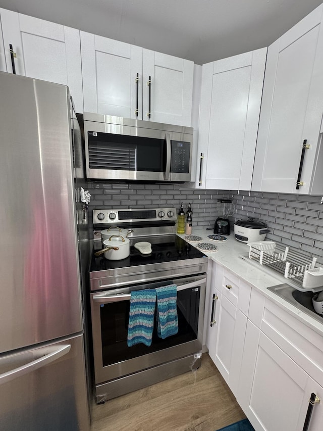 203 S Windsor I Unit 203, West Palm Beach, FL 33417 - kitchen with stainless steel appliances, tasteful backsplash, and white cabinets